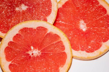 Beyaz arka planda izole edilmiş greyfurt dilimleri. Yuvarlak taze meyve dilimi.