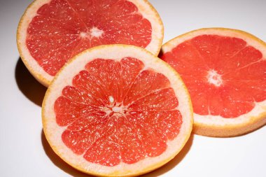 Beyaz arka planda izole edilmiş üç dilim greyfurt. Yuvarlak taze meyve dilimi.