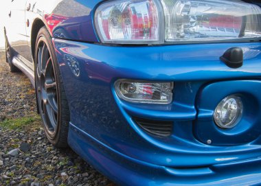 Çakıl yolunda modern tasarımı olan mavi spor araba. .