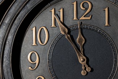 Geceyarısına beş dakika kala altın rengi bir saat..