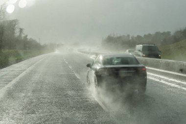 Şiddetli yağmurlu ve kaygan yolda tehlikeli bir araç sürüyor. Soyut bulanık kötü hava aracı otoyolda.