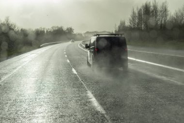 Şiddetli yağmurlu ve kaygan yolda tehlikeli bir araç sürüyor. Soyut bulanık kötü hava aracı otoyolda.