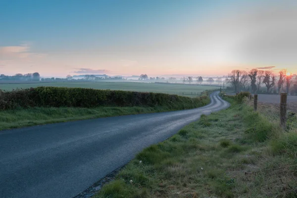 Nascer do sol na Irlanda, fotos paisagem local país com céu azul e nevoeiro ao longo do horizonte. — Fotografia de Stock