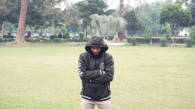 2021 - 2021 salgını sırasında parkta genç bir adamın portresi. Uzak durun. Sosyal mesafeyi koruyun.