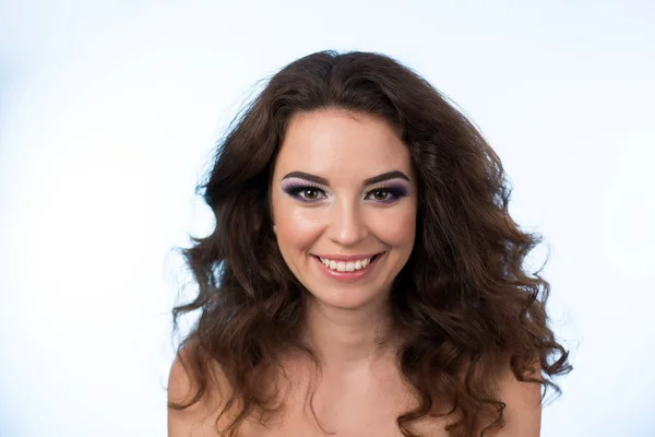 Closeup portrait of young smiling woman with beauty makeup on blue background — Stock Photo, Image