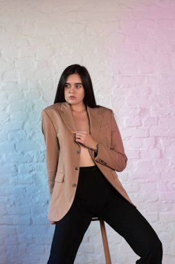 Stüdyoda kahverengi ceketli hoş bir esmer.