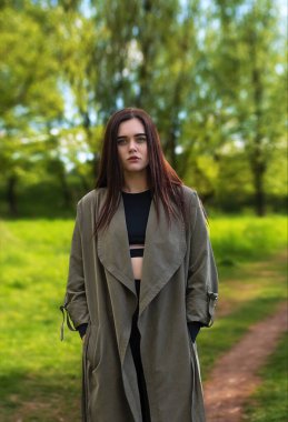 Parkta makyajsız genç ve güzel bir esmer. Güzel bir kızın yakın plan portresi. Açık hava yaşam tarzı. Ciddi kadın.