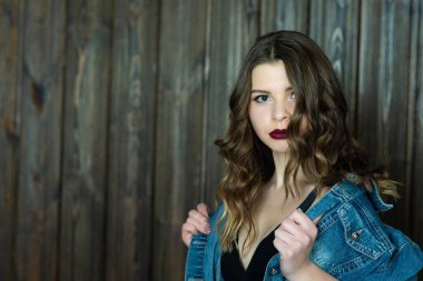 Stüdyodaki genç bayanın yakın plan portresi. Koyu dudaklar, kıvırcık saçlar