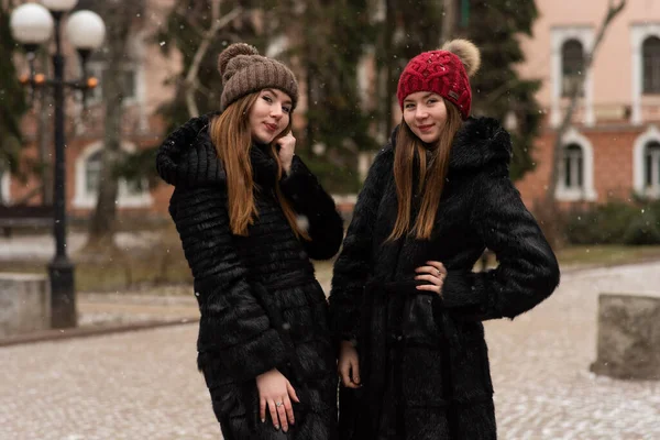 소녀가 포즈를 취하고 있습니다 자매의 사진은 코트를 포옹하며 겨울을 즐겁게 — 스톡 사진