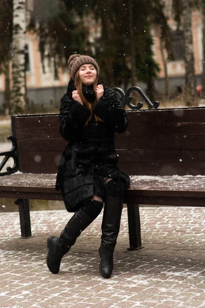 Szczęśliwa Młoda Kobieta Siedzi Ławce Zimie Zewnątrz — Zdjęcie stockowe