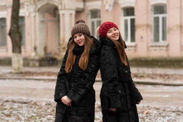 소녀가 포즈를 취하고 있습니다 자매의 사진은 코트를 포옹하며 겨울을 즐겁게 — 스톡 사진