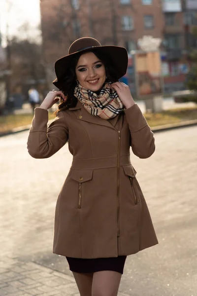 穿着棕色外套和围巾在城里走来走去的漂亮姑娘 — 图库照片