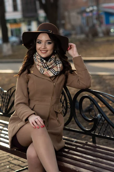 Hermosa Joven Con Abrigo Marrón Sombrero Sienta Banco Parque Ciudad —  Fotos de Stock