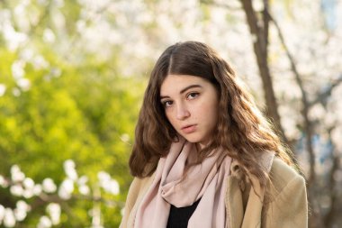 Bahar bahçesinde filizlenen kayısı ağaçlarının arasında genç bir kadının portresi