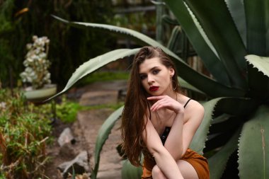 Güz parkında poz veren güzel genç bir kadın.