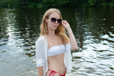 Güzel genç bir kadın nehirde dinleniyor