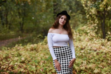 Sonbahar parkında yürüyen şehvetli genç kız. 