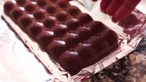 Barra de chocolate con burbujas de menta en el interior con parte de ella que se rompe a mano. Full HD 1920x1080 — Vídeos de Stock