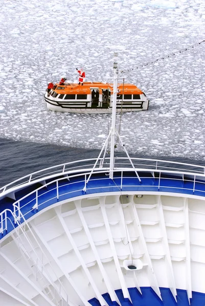 Cruise Ship bow passing icy snow arctic waters near Spitsbergen, Svalbard, Norway with lifeboat on water (Santa Clous on top view). — Stock Photo, Image