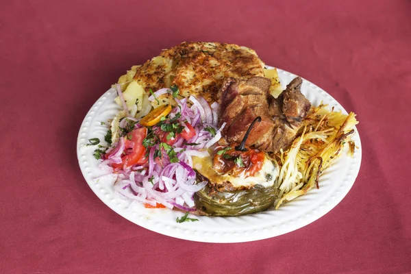 Peruvian Dish: "Doble" din Arequipa. Porc prăjit (Chicharron), cartofi zdrobiți (pastel de papa), ceapă, roșii, spaghete cu brânză (tallarin de queso) și piper fierbinte umplut cu carne (rocoto relleno ) — Fotografie, imagine de stoc