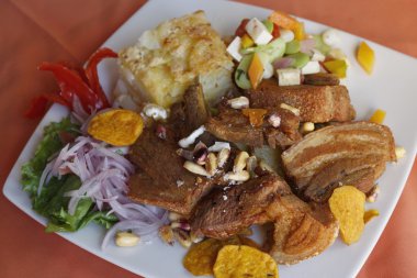 Perulu gıda, kızarmış domuz eti (Chicharron) patates, soğan garnitür, kızarmış Mısır (canchita).
