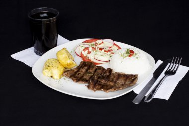 Perulu yemek biber sosu, pirinç, patates, domates ve salata ızgara sığır filetosu muhtelif