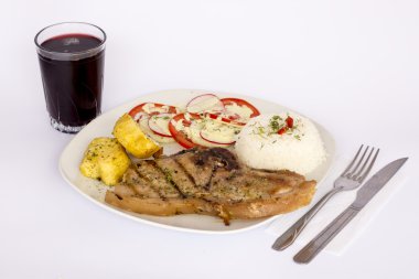 Bir cam ile ızgara biftek domuz eti salatası, pirinç, patates, domates ile servis