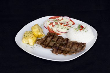 Perulu yemek biber sosu, pirinç, patates, domates ve salata ızgara sığır filetosu muhtelif