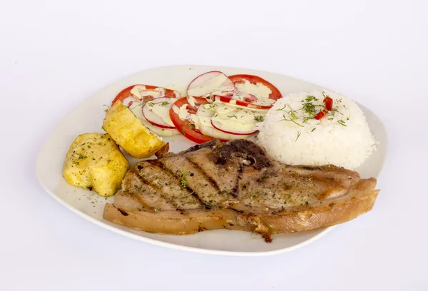 Мясо из свинины на гриле с салатом, рисом, картошкой, помидорами и стаканом — стоковое фото