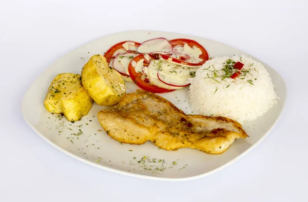 Gegrilde vis en groenten, aardappelen, rijst, tomaten en een glas chicha, — Stockfoto
