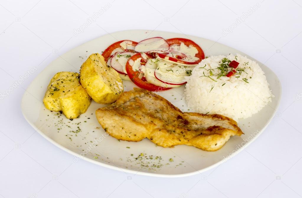 Grilled fish and vegetables, potatoes, rice, tomatoes and a glass of chicha,