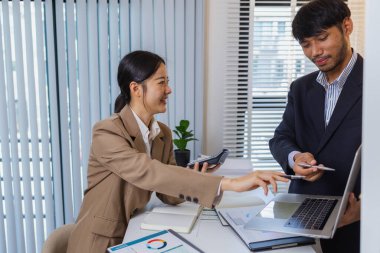 İş arkadaşları aktif olarak ortak bir toplantıda, çizelgeleri gözden geçiriyorlar, verilere işaret ediyorlar ve fikir alışverişinde bulunuyorlar. Takım çalışmaları strateji planlaması, analiz ve işbirliğini yansıtır..