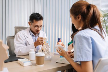 Klinik bir ortamda işbirliği yapan doktor ve hemşirelerden oluşan bir ekip, tedavi seçeneklerini değerlendiriyor ve etkili hasta merkezli sağlık çözümleri sunmak için tıbbi görüşleri paylaşıyor..