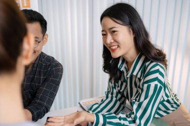 UX / UI tasarımcılarından oluşan bir grup, modern bir tasarım ofisinde yeni mobil uygulama arayüzü için renk paletleri ve konseptleri tartışarak yaratıcı fikirler üzerinde birlikte beyin fırtınası yapıyorlar..