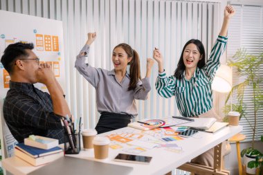 Mobil uygulama düzeni ve kullanıcı akışını iyileştirmek için UX / UI planlama toplantısı düzenleyen tasarımcılar. İşlevsel ve görsel arayüz çözümleri yaratmak için yakın işbirliği yaparlar..