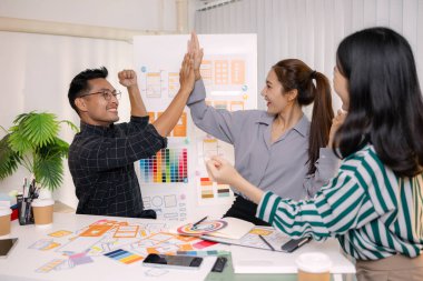 UX / UI tasarımcıları bir yaratıcı atölye sırasında uygulama geliştirme için arayüz fikirlerini test etmek ve geri bildirim alışverişinde bulunmak, takım çalışmasını ve yenilikçi tasarım düşüncesini vurgulamak için işbirliği yaparlar.