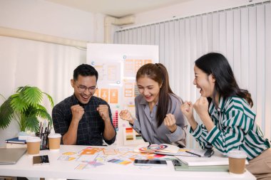 UX / UI tasarımcıları bir yaratıcı atölye sırasında uygulama geliştirme için arayüz fikirlerini test etmek ve geri bildirim alışverişinde bulunmak, takım çalışmasını ve yenilikçi tasarım düşüncesini vurgulamak için işbirliği yaparlar.