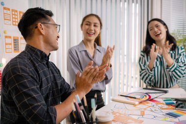 UX / UI tasarımcıları bir yaratıcı atölye sırasında uygulama geliştirme için arayüz fikirlerini test etmek ve geri bildirim alışverişinde bulunmak, takım çalışmasını ve yenilikçi tasarım düşüncesini vurgulamak için işbirliği yaparlar.