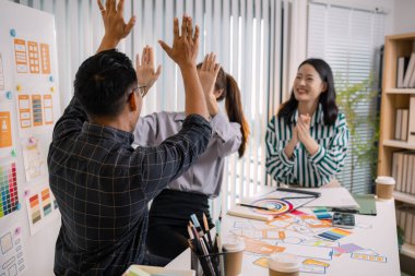 UX / UI tasarımcıları bir yaratıcı atölye sırasında uygulama geliştirme için arayüz fikirlerini test etmek ve geri bildirim alışverişinde bulunmak, takım çalışmasını ve yenilikçi tasarım düşüncesini vurgulamak için işbirliği yaparlar.