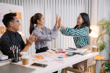 UX / UI tasarımcıları bir yaratıcı atölye sırasında uygulama geliştirme için arayüz fikirlerini test etmek ve geri bildirim alışverişinde bulunmak, takım çalışmasını ve yenilikçi tasarım düşüncesini vurgulamak için işbirliği yaparlar.