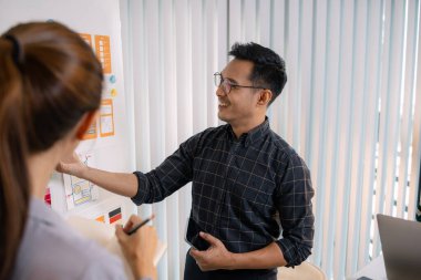 UX / UI tasarımcıları bir yaratıcı atölye sırasında uygulama geliştirme için arayüz fikirlerini test etmek ve geri bildirim alışverişinde bulunmak, takım çalışmasını ve yenilikçi tasarım düşüncesini vurgulamak için işbirliği yaparlar.