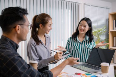 UX / UI tasarımcıları bir yaratıcı atölye sırasında uygulama geliştirme için arayüz fikirlerini test etmek ve geri bildirim alışverişinde bulunmak, takım çalışmasını ve yenilikçi tasarım düşüncesini vurgulamak için işbirliği yaparlar.