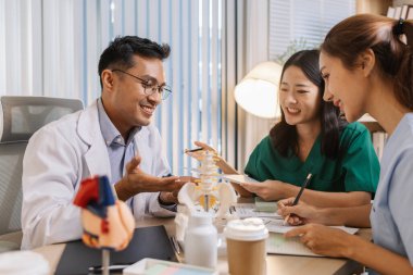 Klinik bir ortamda işbirliği yapan doktor ve hemşirelerden oluşan bir ekip, tedavi seçeneklerini değerlendiriyor ve etkili hasta merkezli sağlık çözümleri sunmak için tıbbi görüşleri paylaşıyor..