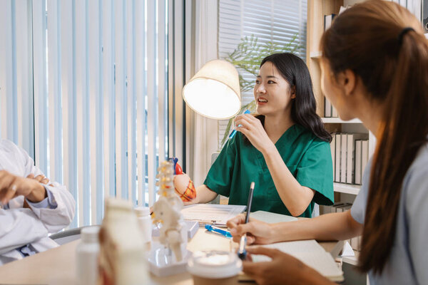 Группа врачей и медсестер консультирует по поводу сложного пациента в больничном кабинете. Команда, анализирующая медицинские данные и обсуждающая планы диагностики точного и эффективного лечения.