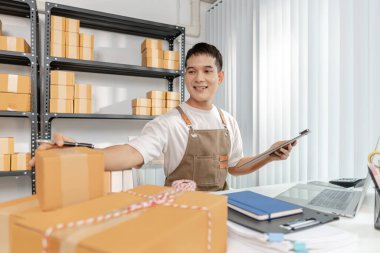 Çevrimiçi ticareti yöneten genç girişimci, paketleri hazırlıyor ve e-ticaret operasyonlarıyla çalışıyor, dijital pazarı, başlangıç büyümesini ve modern perakende stratejisini temsil ediyor.