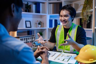 Bir grup mühendis ve mimar, yaratıcı bir takım çalışması ortamında yenilikçi modern binalar tasarlamak için fikirleri tartışıyor ve teknik planlar paylaşıyor..