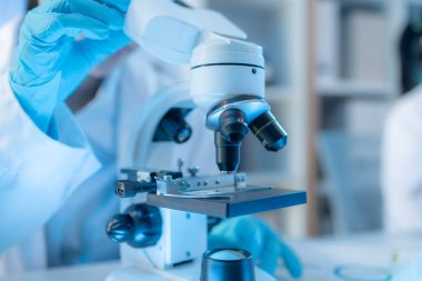 Bilimsel ekipman ve test tüpleriyle çevrili bir laboratuvarda kimya araştırmacısı, yenilikleri, bilimsel gelişimi ve modern tıbbi araştırma ortamını temsil ediyor..