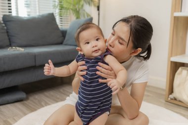 Sevgi dolu bir anne bebeğiyle kaliteli zaman geçirir, karnını doyurur, yuvarlanır ve oturur. Bu hassas anlar evde aile bağlarını, bakımlarını ve çocuk gelişimini yansıtıyor.