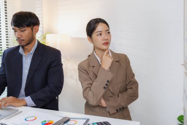 Ciddi bir ofis tartışmasına katılan bir grup profesyonel, mali raporları analiz ediyor ve sorunları çözmek ve etkili kurumsal kararlar almak için fikir alışverişinde bulunuyor..