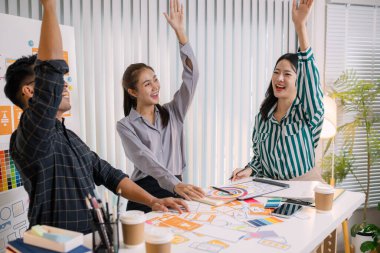 Mobil uygulama düzeni ve kullanıcı akışını iyileştirmek için UX / UI planlama toplantısı düzenleyen tasarımcılar. İşlevsel ve görsel arayüz çözümleri yaratmak için yakın işbirliği yaparlar..